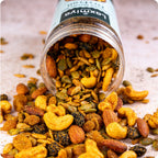 Spicy masala dry fruit mix with nuts and seeds spilling from container